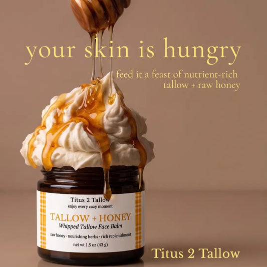 A jar of Titus 2 Tallow whipped tallow face balm topped with whipped cream and dripping honey, with a wooden honey dipper above. Large text reads 'your skin is hungry' and 'feed it a feast of nutrient-rich tallow + raw honey'.